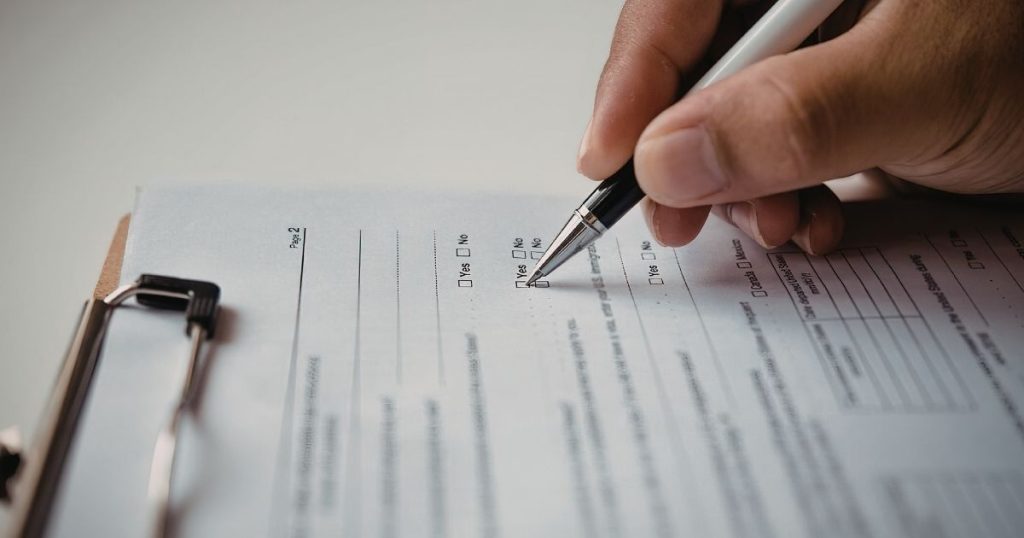 Operatore compila il formulario rifiuti in formato digitale su tablet nell'area di carico di un'azienda